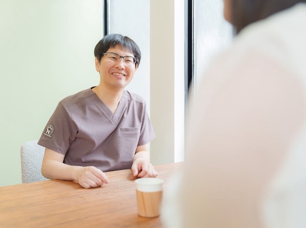 院内での問診・カウンセリングの様子。院長が患者様と向かい合って話している。